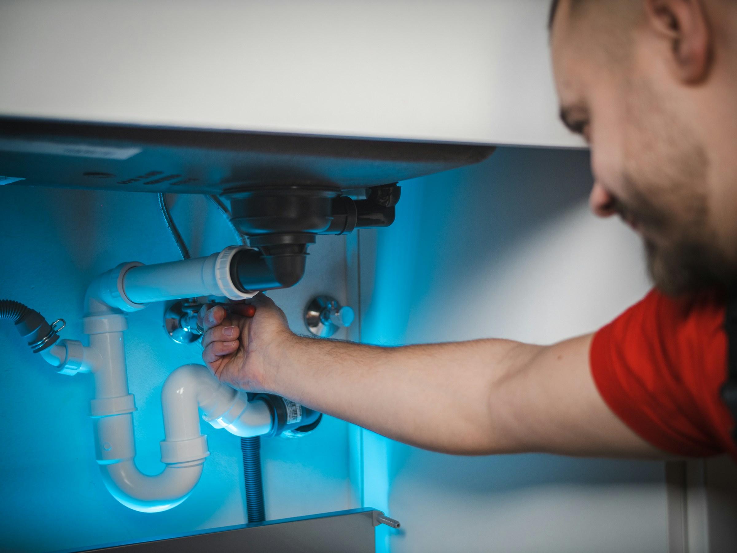 Plumber working on a pipe install, representing the everyday trades Nexa supports